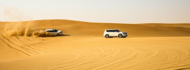 Safari desert Abu Dhabi famille aventure dunes Deux 4x4 traversant les dunes dorées lors d’un safari désert Abu Dhabi en famille