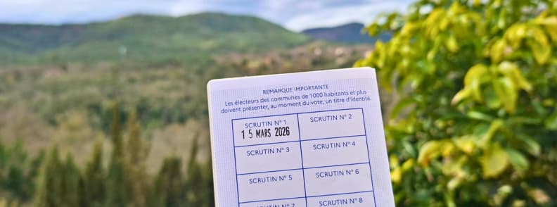 Premier vote aux elections municipales Bagnols en Foret 2026 vie locale Carte électorale française tamponnée le 15 mars 2026 pour les élections municipales à Bagnols-en-Forêt, tenue devant les collines boisées du Pays de Fayence, dans le Var.