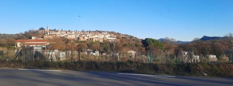 Vue du village perche de Bagnols en Foret depuis la route principale Var Vue panoramique de Bagnols-en-Forêt depuis la route principale, avec le village perché, son clocher, ses maisons provençales et les collines boisées du Var.