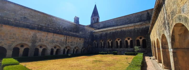 Cloître médiéval de l’abbaye du Thoronet en Provence, architecture cistercienne romane avec galeries voûtées et jardin central lumineux
