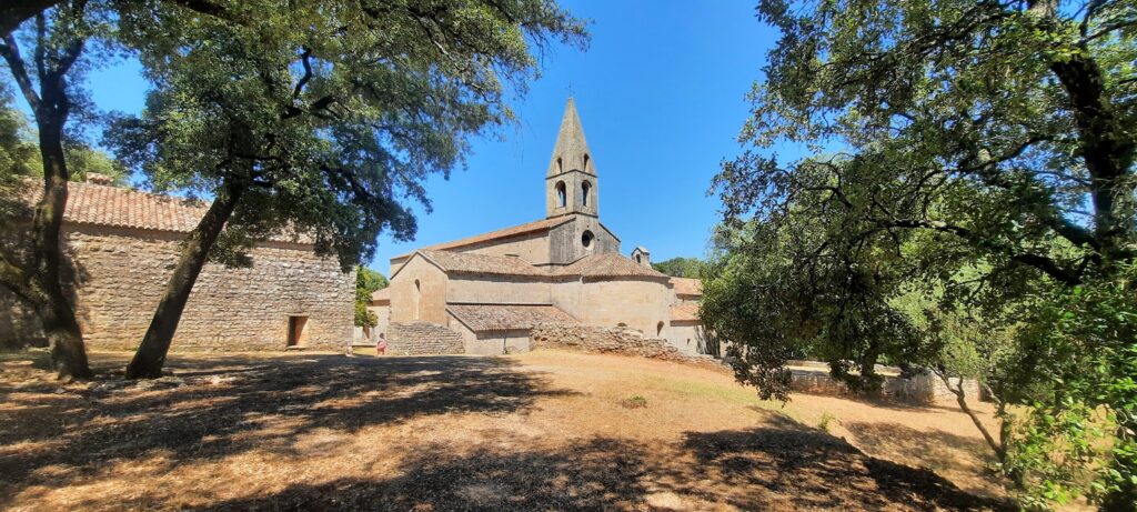Vue extérieure de l’abbaye du Thoronet en Provence, chef-d’œuvre roman cistercien du Var, entourée d’arbres et classée Monument Historique.