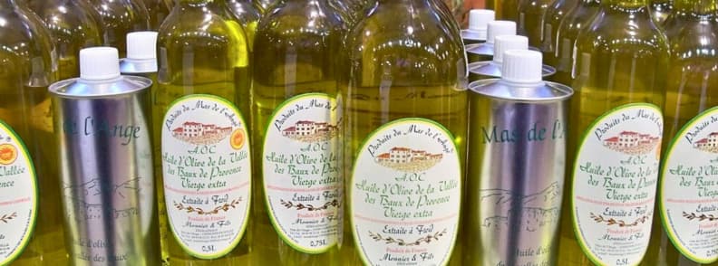 Bouteilles d’huile d’olive AOP Les Baux-de-Provence, exposées pour la vente et la dégustation dans un moulin local.