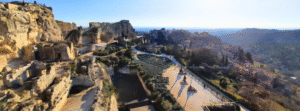 Visite Les-Baux-de-Provence guide. Vue aérienne du Château des Baux-de-Provence avec ruines médiévales, machines de guerre reconstituées et panorama sur le village et les Alpilles.