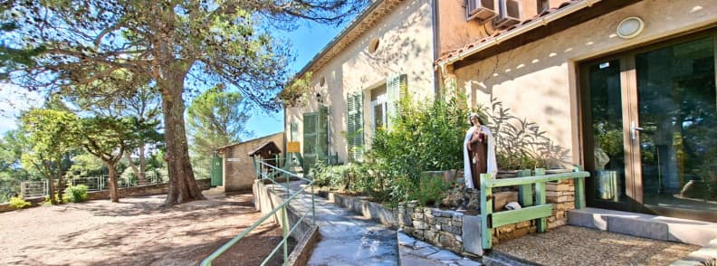 Sanctuaire Notre Dame de Graces Cotignac salle Jean de la Baume Provence Verte Entrée de la salle Jean de la Baume au sanctuaire Notre-Dame de Grâces Cotignac, entourée de pins et de verdure provençale.