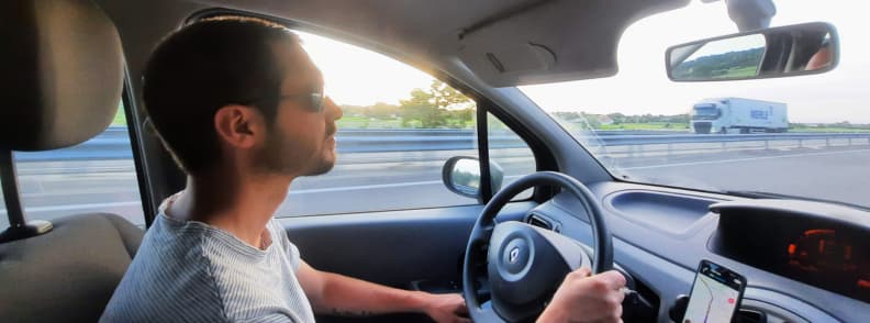 Mathieu Letailleur sur lautoroute en direction de Romans sur Isere pendant un road trip en France avec vue sur la campagne de la Drome