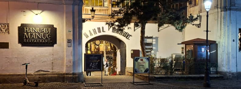 Noel a Bucarest Hanul lui Manuc restaurant hiver Entrée du restaurant Hanul lui Manuc à Bucarest décorée pour Noël dans le centre historique, avec cour intérieure illuminée et ambiance traditionnelle en hiver