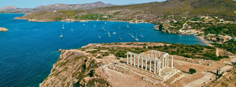 Temple de Poseidon au Cap Sounion pres Athenes dominant la mer Egée avec voiliers en contrebas