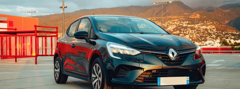 Voiture de location à La Réunion stationnée avec vue sur les montagnes et la ville en arrière-plan