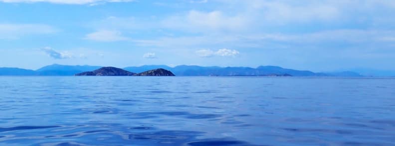 Mer calme dans le golfe Saronique avec îlots rocheux à l’horizon lors d’une excursion en bateau Athènes vers les îles grecques