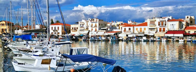 Port des îles saroniques avec voiliers, maisons blanches et eau calme lors d’une croisière d’une journée depuis Athènes