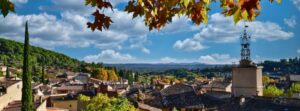Automne en Provence Cotignac en automne village du Var en Provence Automne en Provence. Vue sur les toits de Cotignac en automne, avec des feuillages dorés, des cyprès et les collines du Var sous un ciel bleu nuageux.