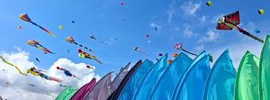 Cerfs-volants colorés et manches à air au Festival International de l’Air de Fréjus, sous un ciel bleu à la Base Nature François Léotard.