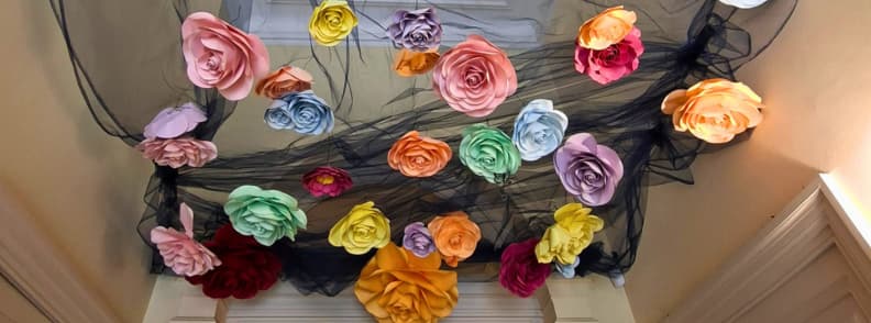 Roses géantes multicolores suspendues à des voilages noirs au plafond de la Villa Aurélienne à Fréjus, pendant le Festival de la Photographie Surréaliste et Créative 2026.