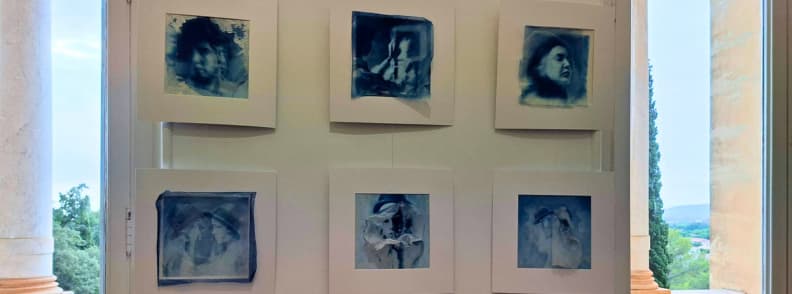 Six portraits fragmentés en cyanotype bleu de JJ Jordan, exposés à la Villa Aurélienne à Fréjus, avec des visages féminins estompés et des effets de superposition.