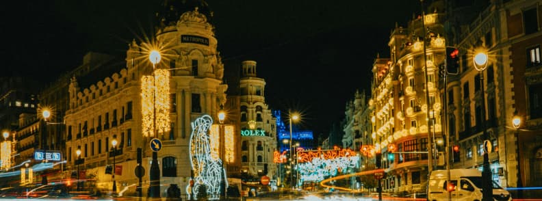 Gran Via Madrid iluminata de sarbatori cu cladiri decorate si instalatii colorate pe timp de noapte
