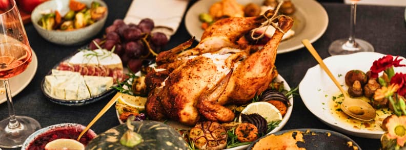 Tururi gastronomice de toamna sejururi culinare si sezonul recoltelor Masă festivă de toamnă cu friptură, legume coapte, brânzeturi și vin, ilustrând atmosfera tururilor gastronomice de toamnă și a sezonului recoltelor