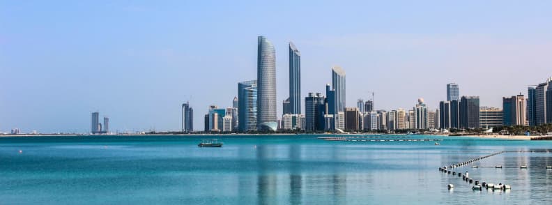 vacanta abu dhabi cu buget redus vedere skyline modern si mare turcoaz Panorama orasului Abu Dhabi cu zgarie nori moderni si apa turcoaz calma intr-o zi insorita