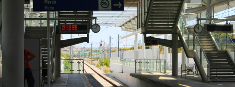 Peroanele gării aeroportului din Atena cu semne pentru metrou și trenuri suburbane care oferă legături rapide spre centrul orașului și alte regiuni ale Greciei