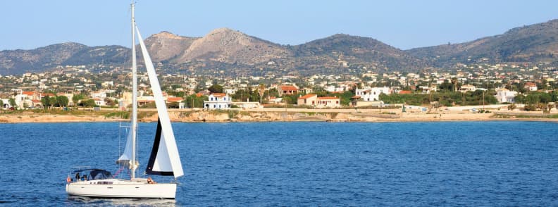Velier pe mare în golful Saronic cu coastă și dealuri în fundal, parte dintr-o croazieră de o zi din Atena