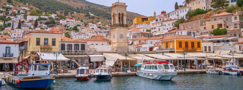 Portul din Hydra Grecia cu turnul cu ceas și bărci ancorate, într-o excursie de o zi din Atena pe insula fără mașini
