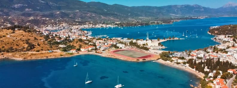 Vedere aeriană asupra portului din Poros Grecia cu apă turcoaz și bărci, parte dintr-o excursie de o zi din Atena