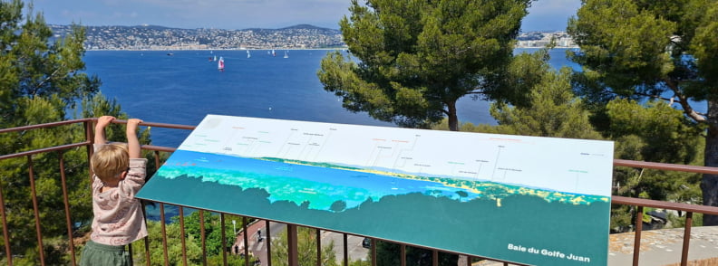 vedere panoramica cap antibes turn graillon golfe juan Copil admiră panorama asupra Golfului Juan de la punctul de belvedere al turnului Graillon din Posidonia Antibes, folosind panoul de orientare amplasat deasupra coastei.