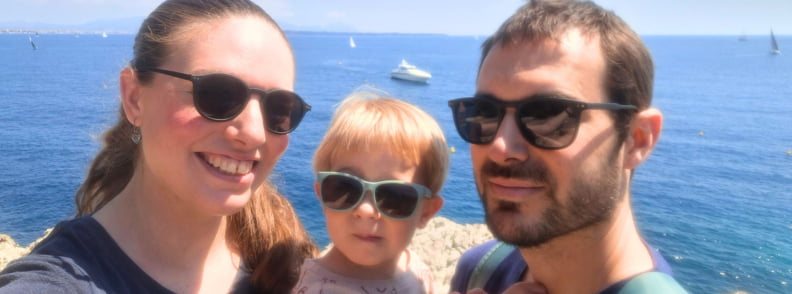 vizita familie posidonia antibes cap antibes cu copii Familie admirând litoralul din Cap d’Antibes în timpul unei vizite la Posidonia Antibes, cu Marea Mediterană și ambarcațiuni în fundal.