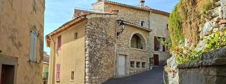 Case din piatra Mons Var sat vechi Provence Case vechi din piatră pe o stradă în pantă din Mons Var, cu arcade, obloane colorate și ziduri stâncoase în centrul satului.