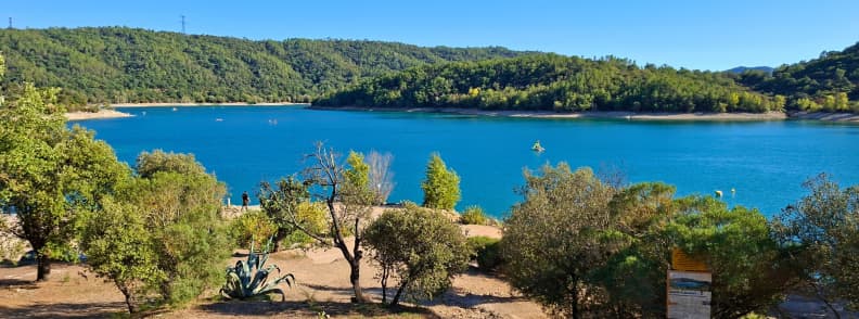 Lacul Saint Cassien Var Pays de Fayence sporturi nautice Lacul Saint-Cassien din Var, cu apă albastră, maluri împădurite și vegetație mediteraneană în Pays de Fayence.