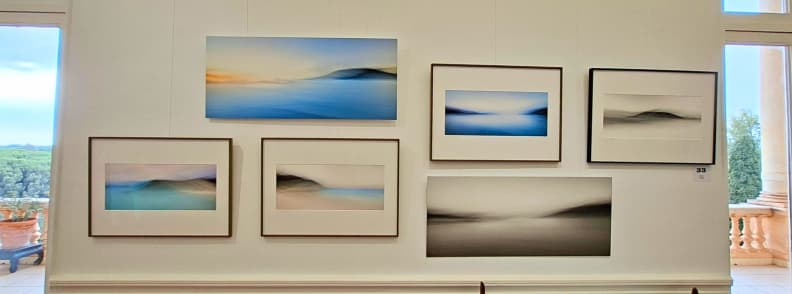 Șase fotografii cu peisaje marine din seria Rémanence de Olivier Busuttil, expuse la Villa Aurélienne din Fréjus, cu orizonturi estompate și nuanțe delicate de albastru și gri.