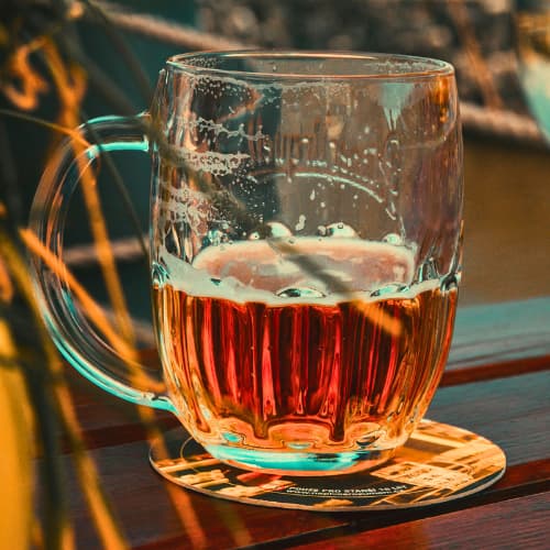 Beer in Prague evening food tour Local Bar Prague evening food tour. Glass mug of Czech beer on a wooden table during an evening in Prague