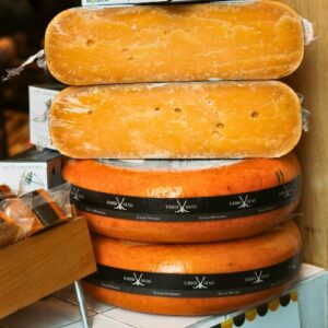Jordaan food tour. Large wheels of Dutch cheese stacked on shelves in an Amsterdam food shop