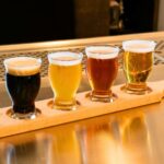 Prague Craft Beer Tour. Flight of Czech craft beers served in small glasses on a wooden tasting board in Prague