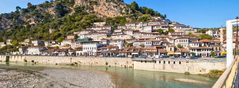 Berat Day Trip From Tirana Albania View of Berat in Albania, with Ottoman houses climbing the hillside above the Osum River, seen on a popular day trip from Tirana.