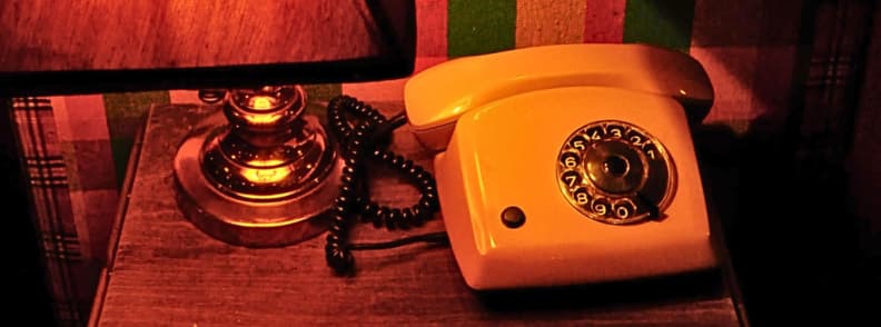 Radio Bar Tirana Reviews Vintage Telephone Decor Yellow rotary telephone beside a vintage table lamp inside Radio Bar Tirana, with warm red lighting and retro furnishings in Blloku.