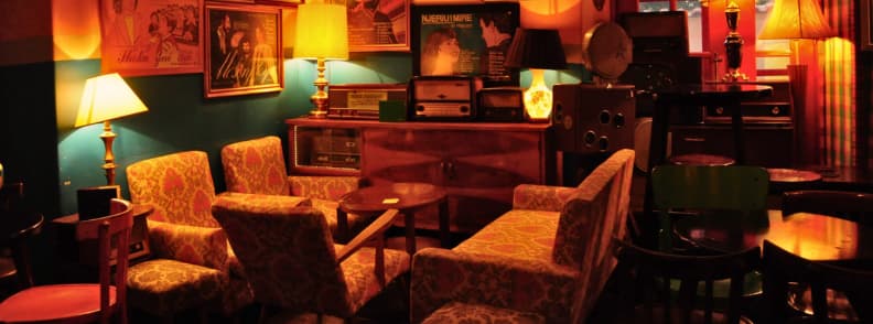 Radio Bar Tirana Vintage Lounge Vintage lounge at Radio Bar Tirana with patterned armchairs, old radios, framed posters, warm lamps, and retro furniture in Blloku.