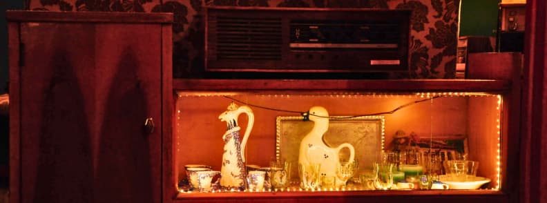 Radio Bar Tirana Vintage Radio Collection Blloku Vintage radio and illuminated glassware display inside Radio Bar Tirana, surrounded by dark wood furniture and retro decor in Blloku.