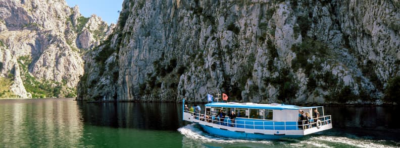 Day Trip to Koman Lake and Shala River from Shkoder Boat cruising across Koman Lake between steep rocky cliffs on a day trip from Shkoder to the Shala River.