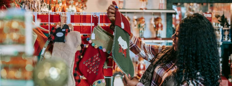 Woman browsing festive Christmas stockings at a decorated shop in Madrid
