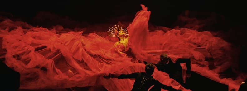 Flamenco dancer in a dramatic red costume performing on stage in Madrid during Christmas