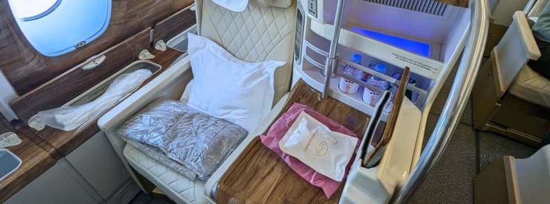 Business Class Sleep Tips Lie Flat Bed Airplane Comfort and Amenities Luxury business class seat with lie flat bed setup, pillow, blanket, and personal storage, showing business class sleep tips for maximizing comfort on long-haul flights.