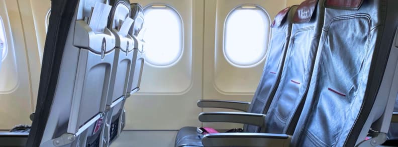 Sleeping in Economy Class Economy Sleep Hacks and Comfort Tips Empty row of airplane seats in economy class, illustrating sleeping in economy class with economy sleep hacks like seat selection, support pillows, and strategic layering for comfort.
