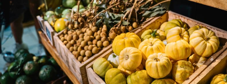 Wooden crates filled with small pumpkins and autumn produce at a local farmers market