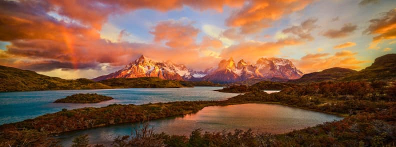 Sunset over Torres del Paine National Park in Chile with autumn colors reflected in lakes and snow peaks
