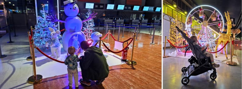 Father and toddler looking at Christmas decorations inside Nice Airport during holiday travel