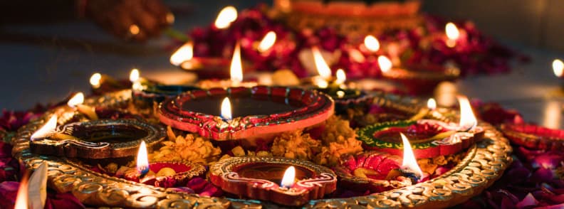 Diwali Festival of Lights India autumn cultural travel Traditional Diwali oil lamps surrounded by marigold flowers and rose petals glowing warmly during the Festival of Lights in India