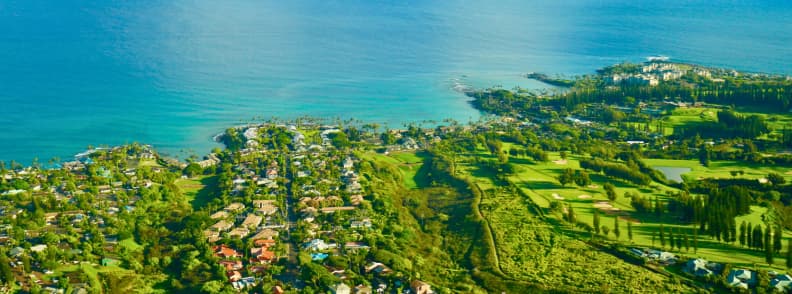 Maui Hawaii Napili Bay autumn vacation Pacific travel Aerial view of Napili Bay Maui showing turquoise waters, coastal homes, and lush green landscapes under bright Hawaiian light