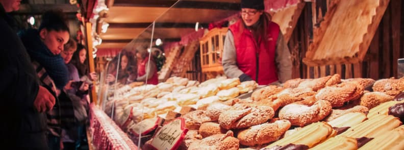 vienna christmas market food stand festive pastries and cookies Vienna Christmas market stall selling traditional Austrian pastries and cookies to warmly dressed visitors during winter