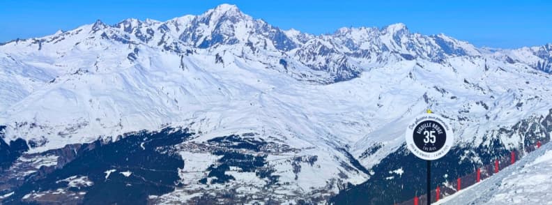 Skiing in France Aiguille Rouge View Mont Blanc Panoramic view of Mont Blanc from the Aiguille Rouge black slope in Les Arcs with a piste marker in the foreground.
