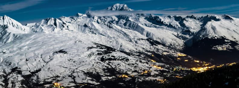 Skiing in France La Plagne Night Alpine Panorama Night view of La Plagne with illuminated villages beneath snowy peaks and the vast Alpine ridge stretching toward the horizon.